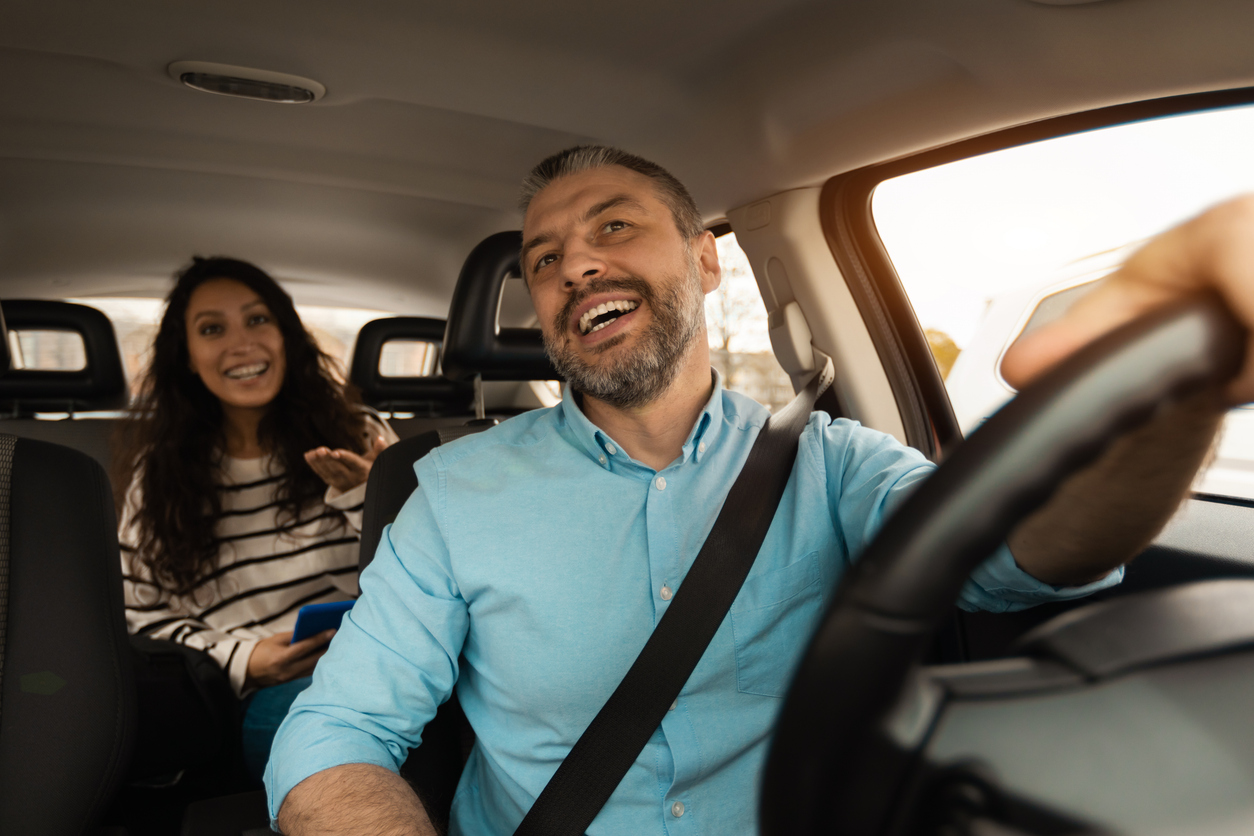 Portrait of happy male driver riding car with passenger booking-taxi