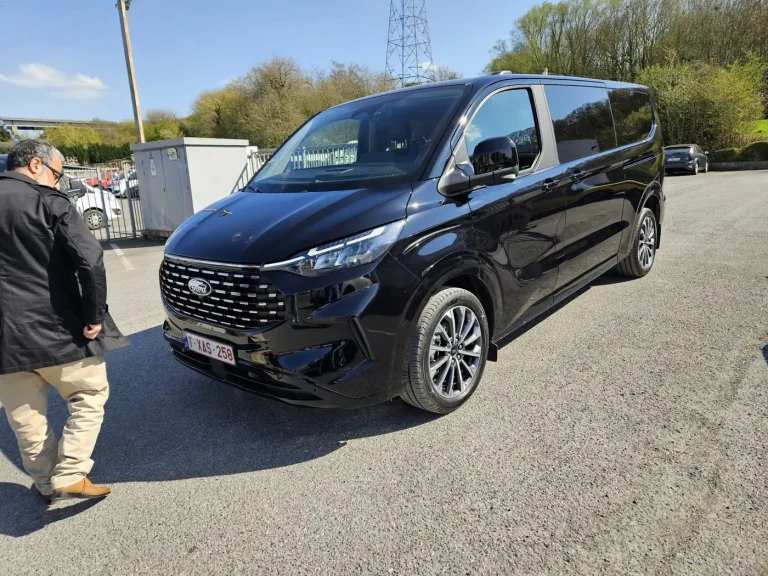 Chauffeur près d'un taxi van Ford noir avant un transfert aéroport