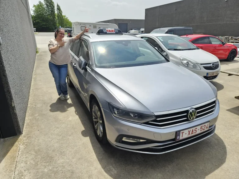 Grijze Volkswagen Passat break als taxi voor een rit naar het station