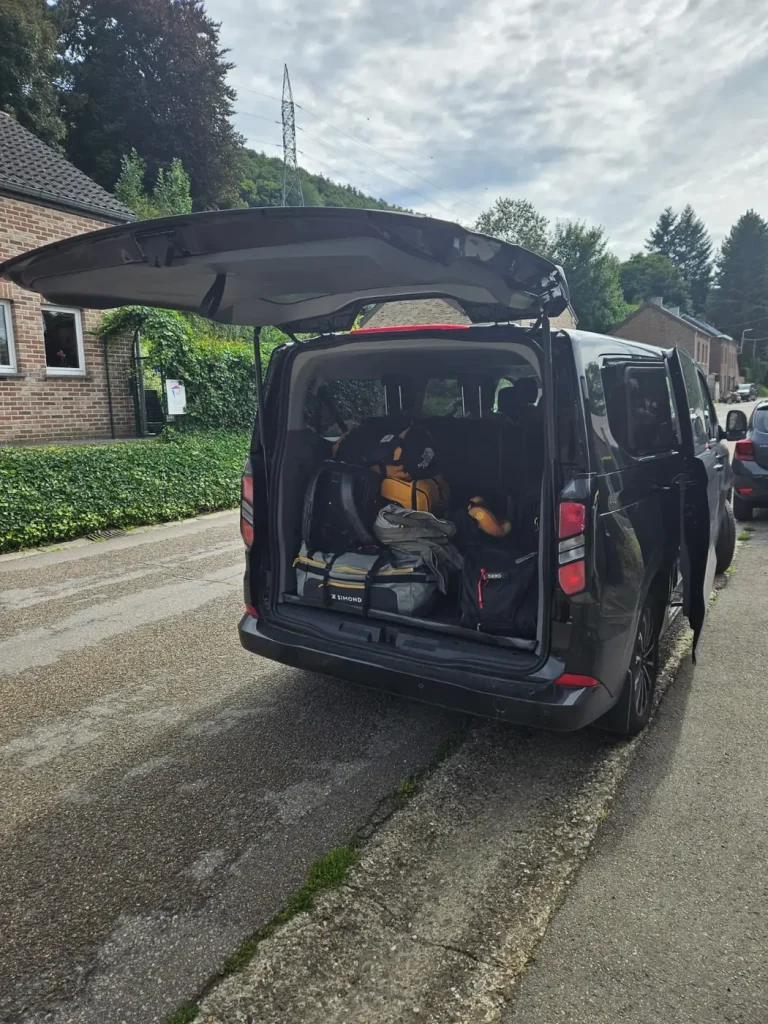 Taxi van coffre ouvert chargé de bagages avant un départ